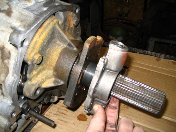 Transmission output shaft with splines, held by a metal housing. A finger is touching the shaft