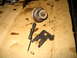 1984 Ford Bronco - A transmission vacuum modulator and linkage are shown disassembled on a stained cardboard surface.