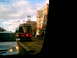 1997 Ford Escort - A silver car is seen from the side as a streetcar passes by in a city.