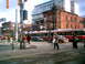 1997 Ford Escort - A busy street intersection in Toronto features a tram, several cars, and pedestrians crossing the road.