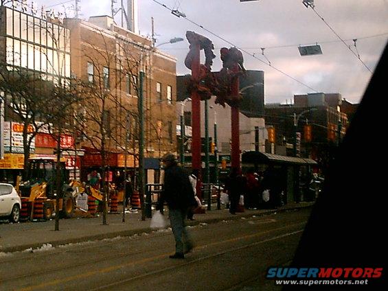 Street scene with construction equipment, buildings, and a pedestrian crossing