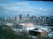 1997 Ford Escort - A wide view of a city skyline on a cloudy day, with snow covering the ground and buildings.
