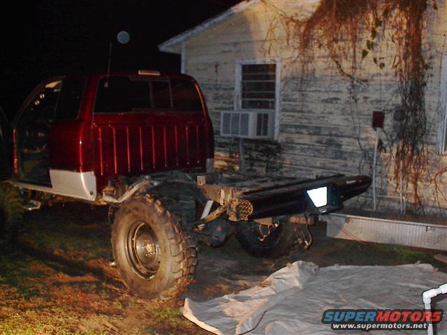 2001 Dodge 1500 pickup truck chassis with cab, red and silver, parked outside a house at night