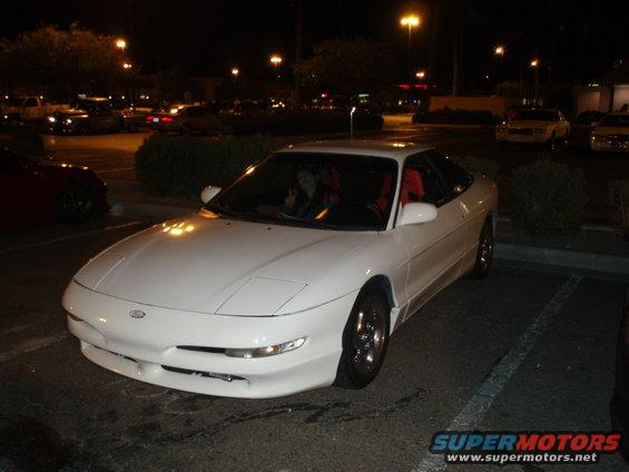 White 1997 Ford Probe with pop-up headlights parked at night