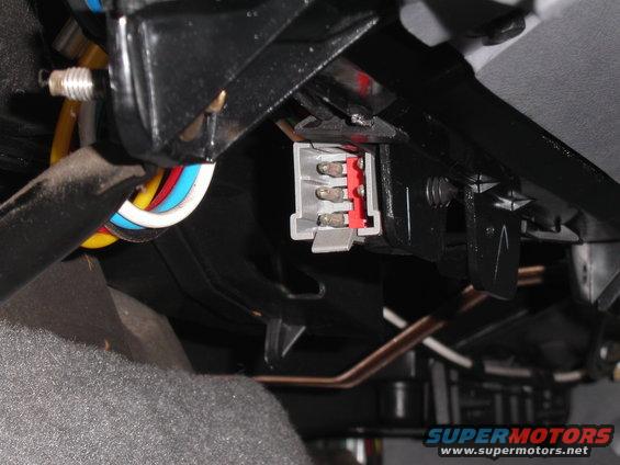 Close-up of a gray and red electrical connector with wires attached