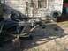 2001 Dodge 1500 - The chassis of a disassembled truck sits on the ground next to a weathered building.
