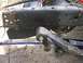 2001 Dodge 1500 - A close-up shows a section of a truck's frame and suspension components, with handwritten markings on a metal plate.