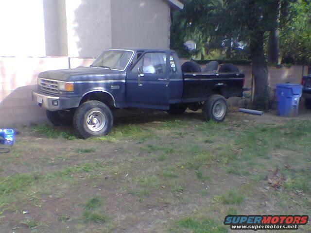 Dark blue 1987 Ford F-250 pickup truck parked on grass, front 3/4 view
