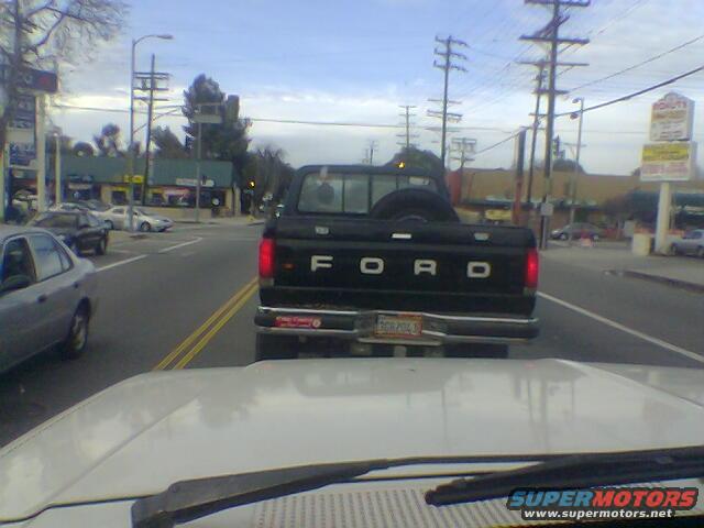 Black Ford pickup truck from behind, with 'FORD' on tailgate. License plate visible