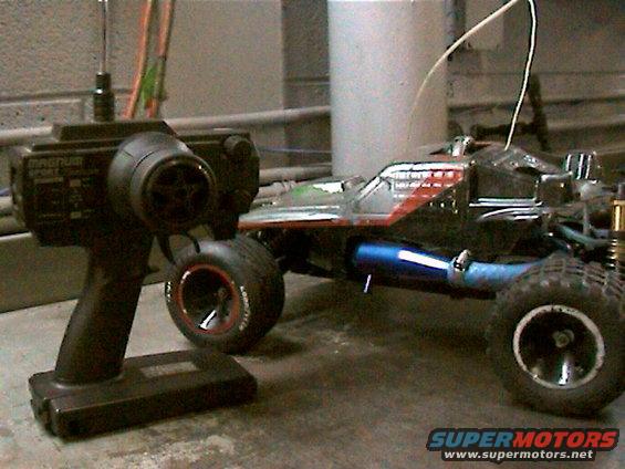 RC car with blue exhaust pipe and a black remote controller with 'MAGNUM SPORT' text