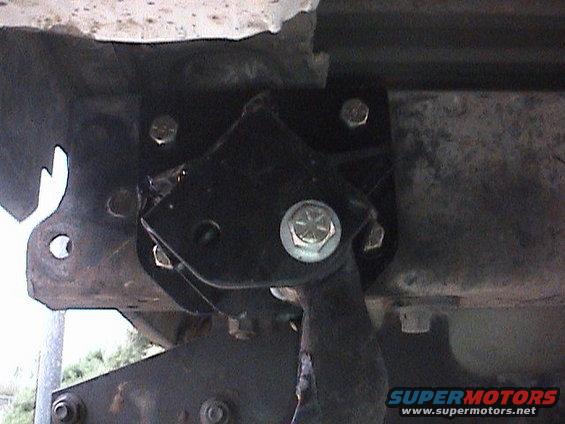 Close-up of a black metal suspension lift bracket bolted to vehicle frame