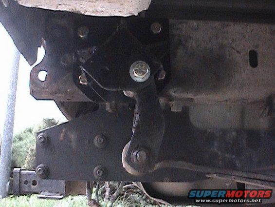 Close-up of a black metal bracket attached to a vehicle's frame, likely part of a suspension lift kit