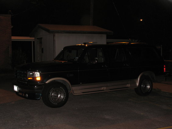 Dark blue Ford Bronco Centurion with tan lower body trim, seen at night from a 3/4 front angle