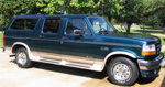 Dark green and silver SUV with chrome trim and running boards, seen from a 3/4 front angle