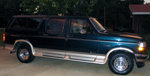 1995 Ford C-150 Centurion conversion van, dark green with silver trim, parked outside