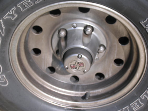 Close-up of a silver wheel hub with a "4x4" emblem and tire tread