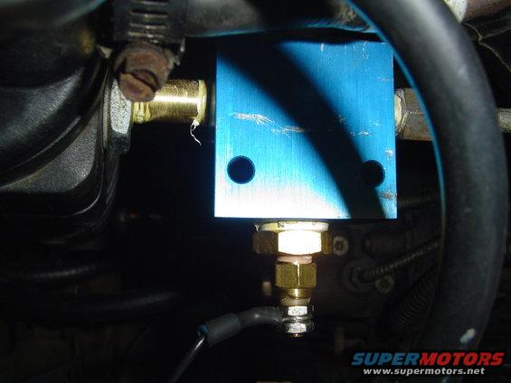 Close-up of an engine part with a blue housing and brass fittings
