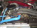 1993 Ford Bronco - Close-up view of an engine bay, blue hoses and a fan shroud with a warning label.