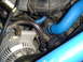 1993 Ford Bronco - Close-up view of engine components, including blue hoses and an alternator, with a website watermark.