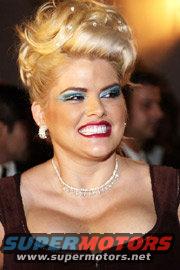 woman with big hair and makeup, wearing a necklace
