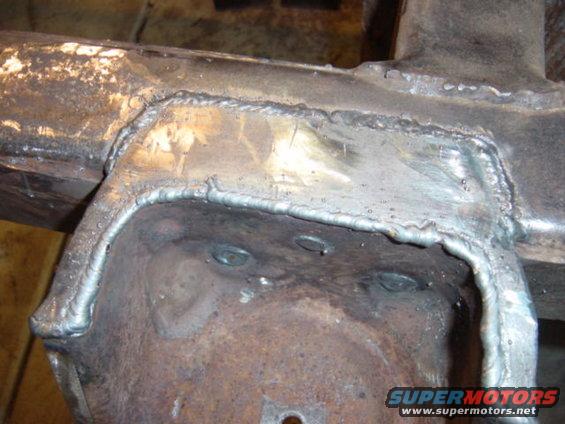 Close-up of a welded section on a vehicle frame, showing repair work