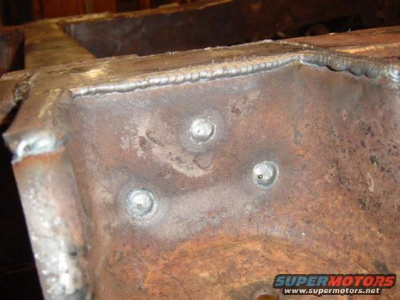 Close-up of rusted metal frame with visible welds and bolt heads
