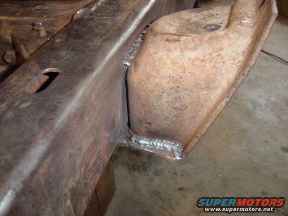 Close-up of a rusty metal frame section with fresh welds