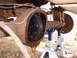 1988 Ford Bronco - The rear differential is open, showing gears and old fluid leaking out. The vehicle is supported by jack stands.