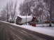 1984 Ford Bronco - A semi-trailer truck is stuck at an angle in the snow, with a pickup truck visible on the side of the road.