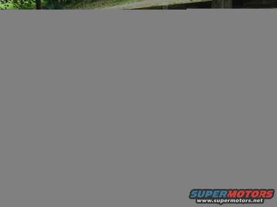 1995 Honda FOURTRAX 300 ATV, red body, parked on dirt path with trees in background