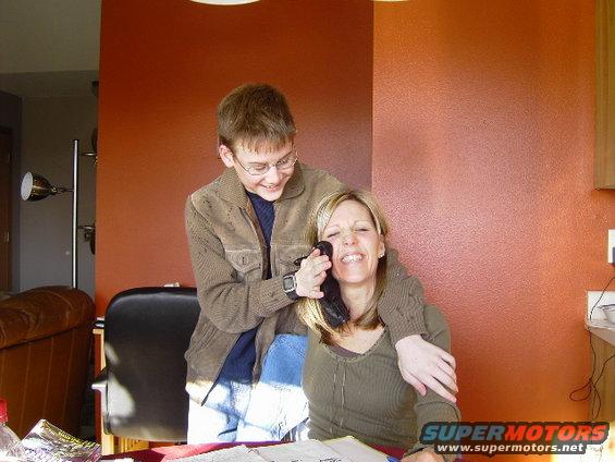 Kid holding phone to mom's face while she laughs