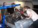 1967 Ford Mustang - Mechanics use an engine hoist to remove the engine from a 1967 Ford Mustang in a garage.