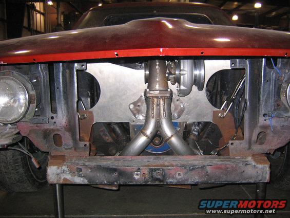 1969 Ford Mustang front end with custom turbocharger installation, red hood, rusty bumper