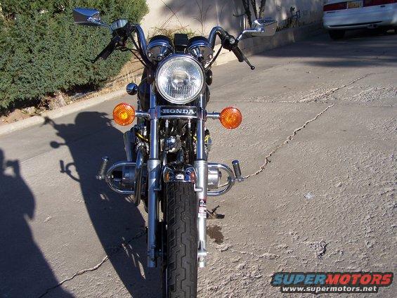 Front view of a Honda motorcycle with chrome details and orange turn signals