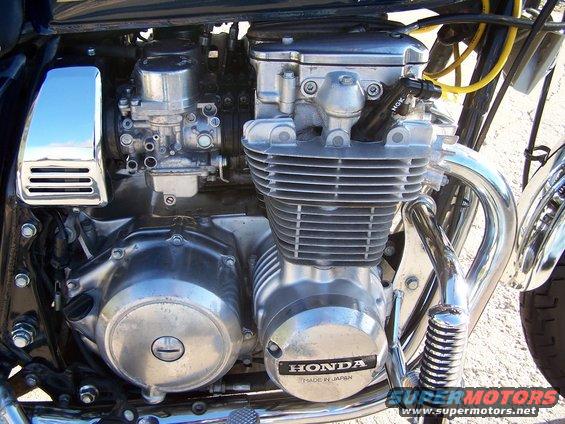 Motorcycle engine with Honda badge, chrome accents, and visible spark plug wire