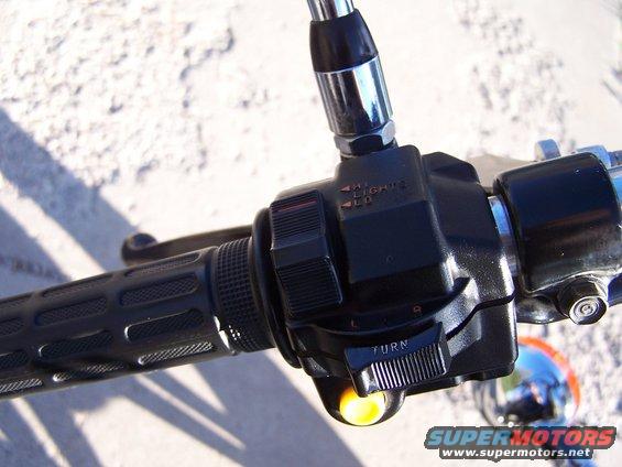 Motorcycle handlebar with black grip, turn signal switch, and headlight controls labeled HI/LO