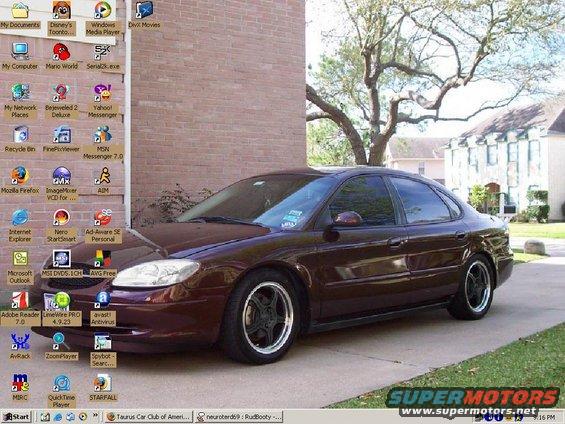 Desktop computer screen showing a dark red sedan as wallpaper, with various program icons on the left