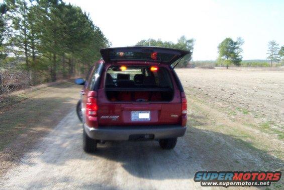 Red 2005 Ford Explorer parked on a dirt road with its rear hatch open