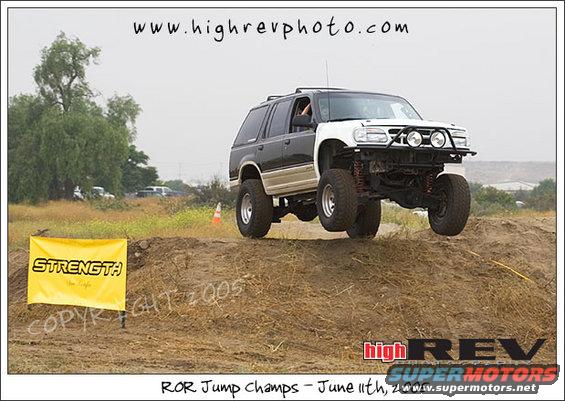 Black and white SUV mid-air jump, lifted suspension, off-road tires