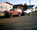 1989 Ford Bronco - Two Ford Broncos, one red and one light blue, are parked on a residential street.