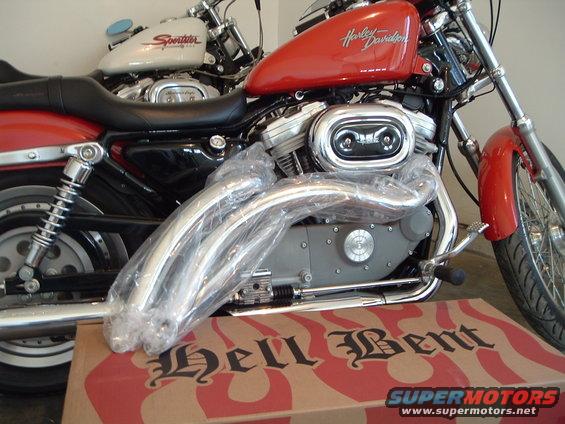 Red 2002 Harley-Davidson Sportster Custom motorcycle, 3q-front view, with chrome exhaust pipes