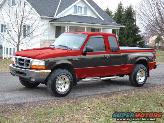 Red and black Ford Ranger pickup truck parked in front of a house. The grille and headlights suggest a 1998 model year