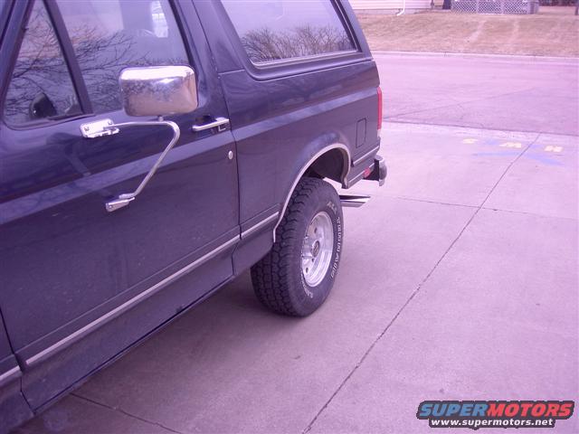 Dark blue SUV side view, showing chrome mirror and trim