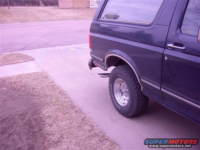 Dark blue SUV parked on a driveway, showing the rear wheel and side panel