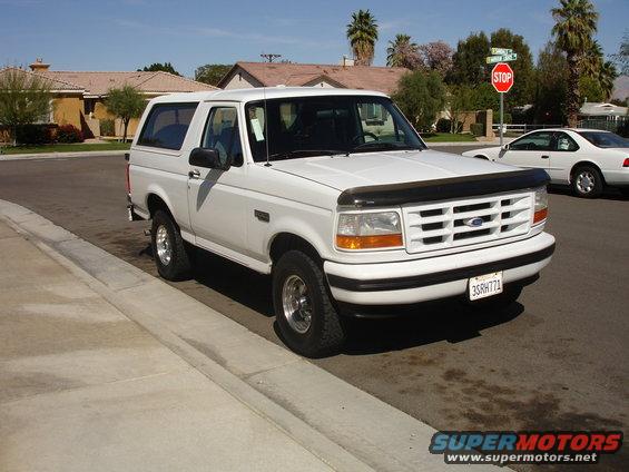 White 1996 Ford Bronco parked curbside, front grille visible