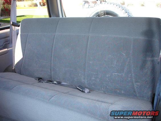 1996 Ford Bronco rear seat with seatbelts visible, spare tire mounted behind seat