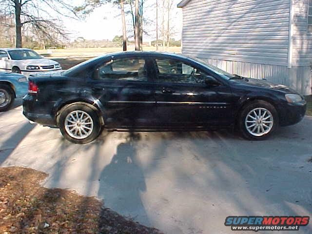 Black sedan parked next to a white car and a blue car