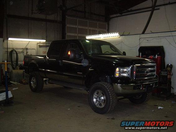 Black pickup truck with chrome grille and aftermarket light bar