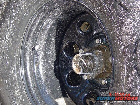 Close-up of a wheel hub and tire with water droplets