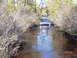1995 Dodge 1500 - Two trucks navigate a flooded path surrounded by trees and brush.